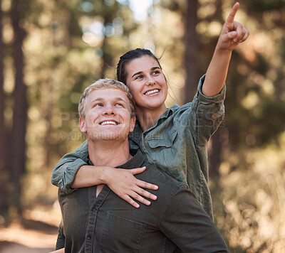 Buy stock photo Couple piggy back, happy and hiking in nature, relax or smile, hand and pointing while trekking in nature. Friends, hikers and woman with man in forest, exercise, cardio or adventure outdoor together