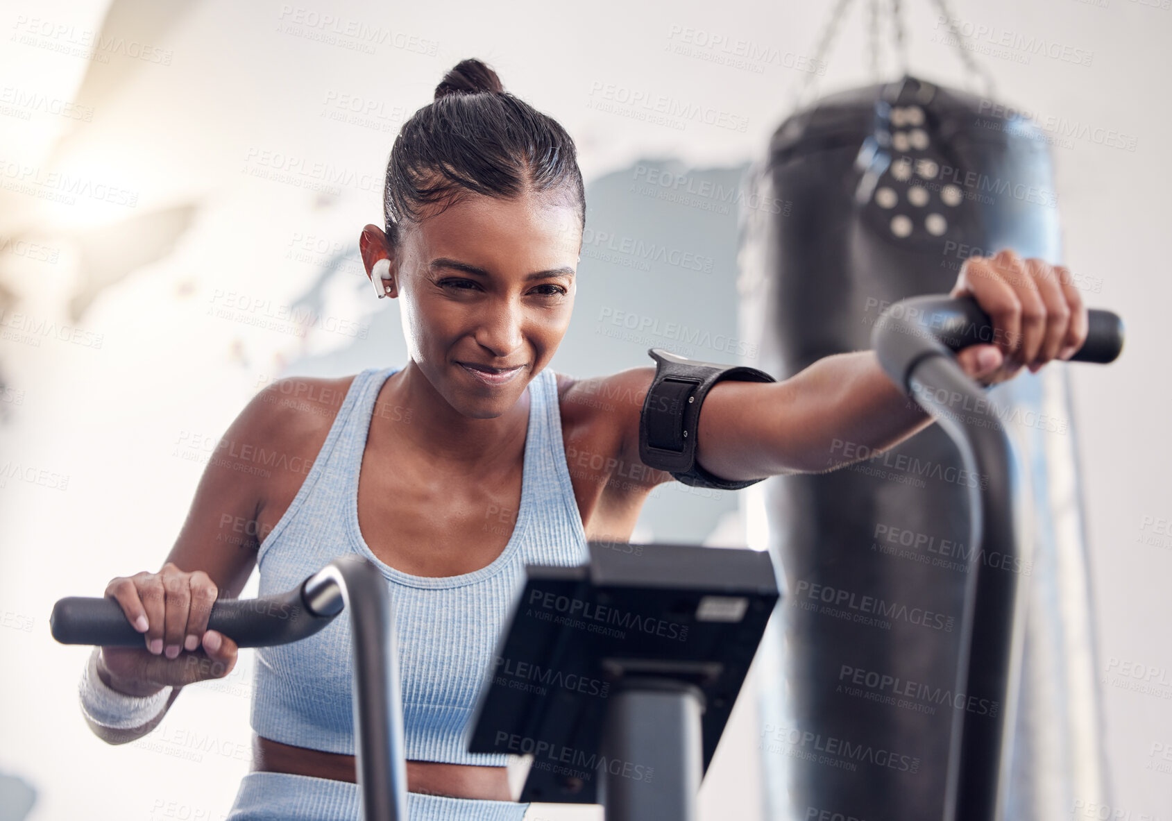 Buy stock photo Fitness, gym and black woman on an exercise bike doing a cardio, leg and intense workout for wellness. Sports, strong and young athlete training on an electric bicycle with motivation in sport studio