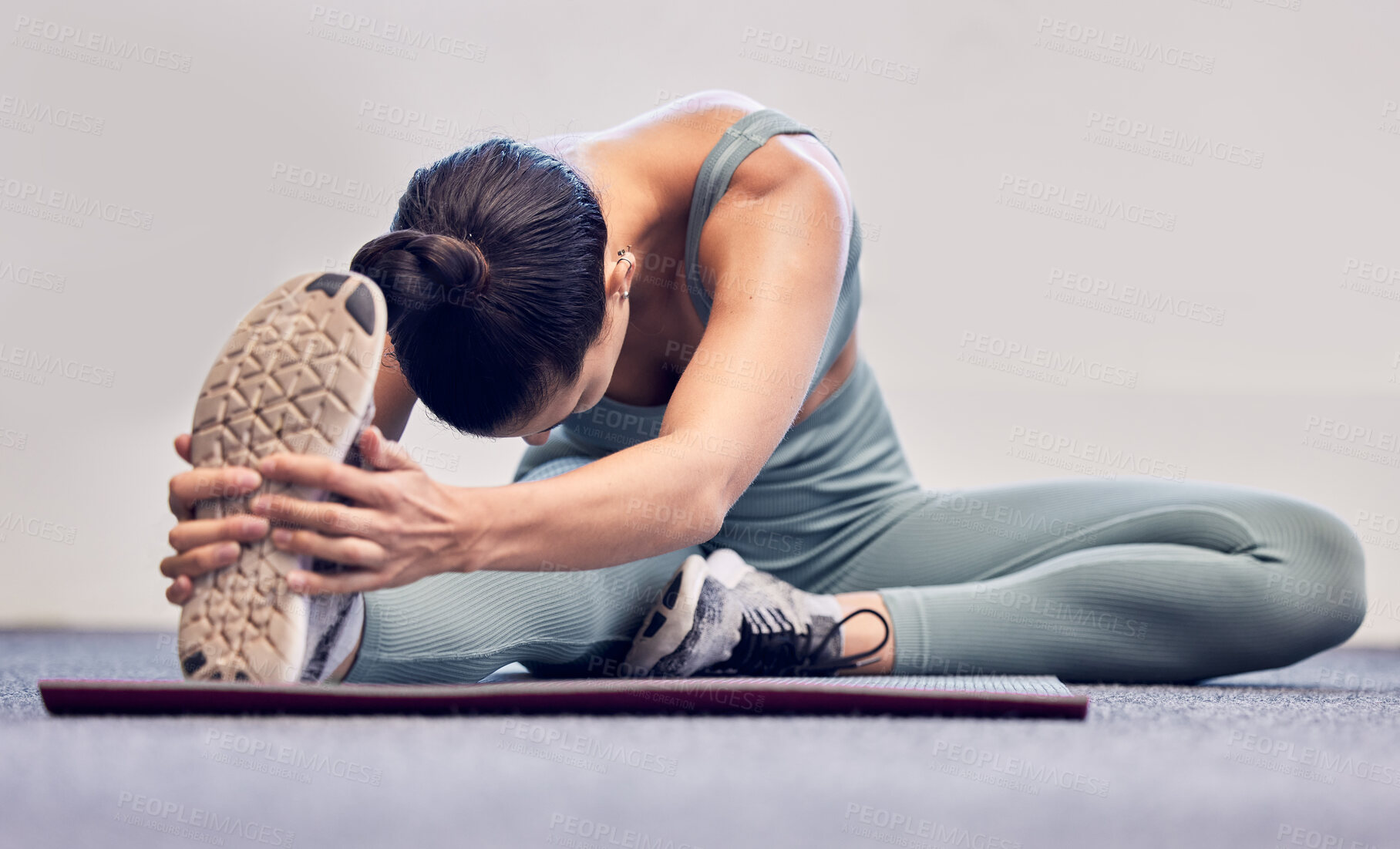 Buy stock photo Yoga, fitness and stretching woman on floor for body wellness, exercise and healthy lifestyle with wall mockup for marketing. Sports athlete girl with foot or sneakers in cardio, pilates and workout