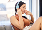 Headphones, music and woman on sofa listening to podcast streaming service with student discount subscription for mental health wellness. Relax, calm and peace of young gen z girl on audio sound tech