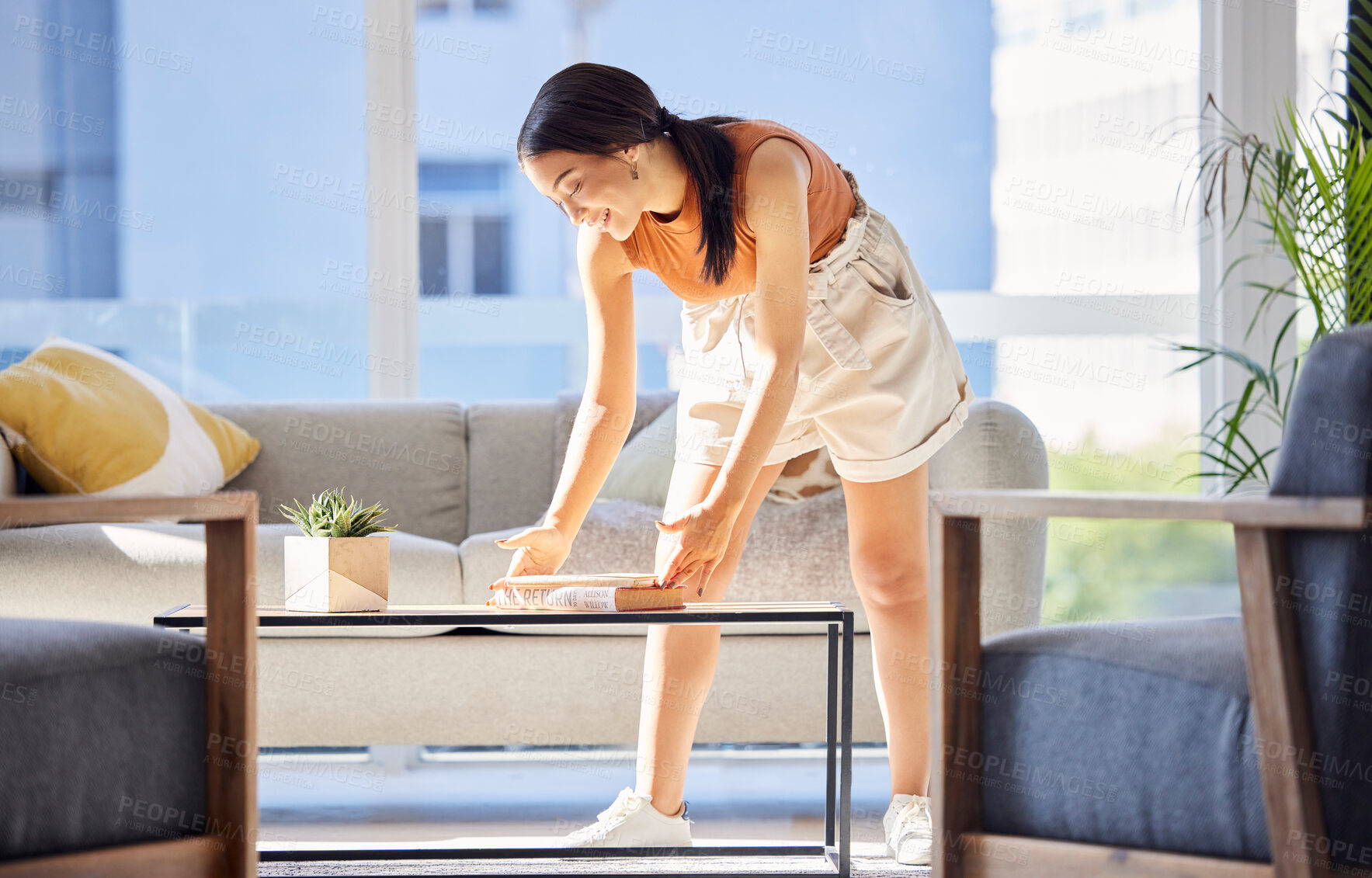 Buy stock photo Woman, cleaning and books on home table for organisation,  happiness and housework in lounge. Clean and happy girl satisfied with tidy living room book arrangement in Philippines house.