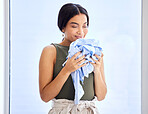 Laundry, cleaning and smell with woman and clothes for fresh, fragrance and aroma from housekeeping. Fabric, cleaner and soft with girl enjoying scent of detergent, care and sanitary on material
