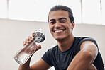 Fitness, water bottle and portrait of a man on a break after an intense workout or training in the gym. Sports, rest and happy athlete drinking a beverage while resting after exercise in sport center