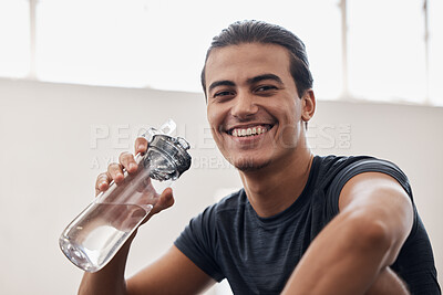 Buy stock photo Fitness, water bottle and portrait of a man on a break after an intense workout or training in the gym. Sports, rest and happy athlete drinking a beverage while resting after exercise in sport center