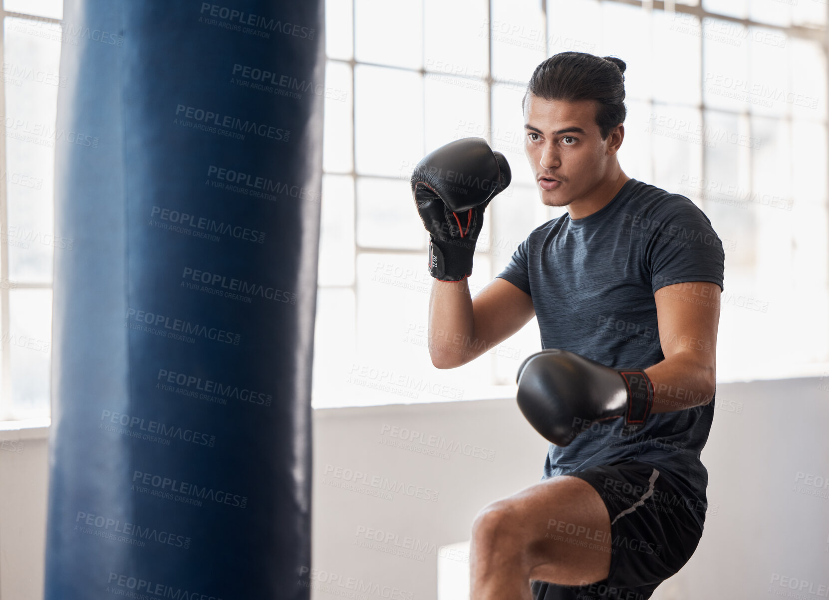 Buy stock photo Fitness, boxing and man training for a fight competition, workout or match with a boxing bag in the gym. Sports, motivation and athlete boxer doing MMA exercise to practice in fighting dojo or studio