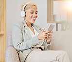 Business woman, headphones and phone streaming of music or video in a office with technology. Black woman smile on social network, music or web app on a sofa listening to funny podcast