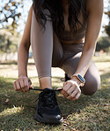 Fitness, running and woman tie shoes in grass of park for training, workout and ready. Exercise, health and wellness with girl runner and start for cardio, sprinting or endurance jogging in nature