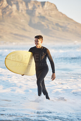 Surfing sports and man walking from ocean with smile, surfboard in hand and happiness in summer. Nature, water sports and male surfer on beach shore after fitness, exercise and cardio for wellness
