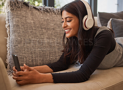 Buy stock photo Relax, headphones and woman with phone, sofa and home living room streaming online music, podcast or radio. Happy, smile and happy female enjoy listening to audio, playlist or favorite song in house