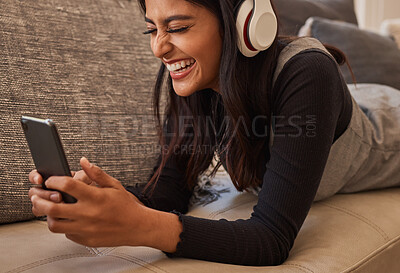 Buy stock photo Smartphone, headphones and woman on sofa listening to music, watch online video chat or mobile app zoom call. Excited, relax and music of a youth girl audio, podcast or online subscription streaming