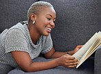 Book, relax and black woman reading on a sofa for knowledge in the living room of her house. Happy, smile and African girl enjoying a fantasy story or novel while relaxing on the couch at her home.