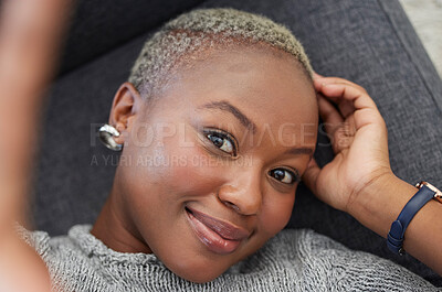 Buy stock photo Smile, black woman on sofa and phone selfie, taking a profile picture for social media or online dating app. Relax, happy and woman laying on living room couch taking photo for self love from above.