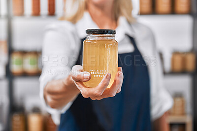Buy stock photo Glass, honey and hand of woman small business owner offering raw, organic and healthy product in her store. Local business, businesswoman and honey jar in a market, eco friendly and sustainable 