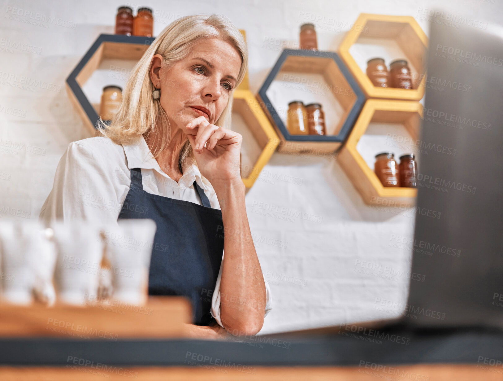 Buy stock photo Stress, laptop and honey store owner with anxiety, business fail and loss from inflation, depression and worry. Senior woman, small business and issue at startup organic shop search online solution