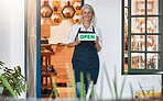 Entrepreneur, startup small business and woman with an open sign for her retail honey store. Happy, smile and portrait of a senior female owner of natural, raw and organic shop standing with a board.