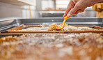 Hands, honey frame and harvest tool for uncapping beeswax at bee farm. Honey industry, farming worker and beekeeping person collecting organic, healthy or natural food product at manufacturing plant
