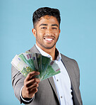 Businessman, money and rich with cash, income and happy with profit, salary and finance currency in blue mockup studio background.  Investment, male employee or working in economy or financial growth