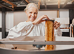 Portrait, beekeeper and honey manufacturing, process and frame in agriculture factory, workshop and industry. Farmer employee, happy smile and farming production, manufacturing and honeycomb process 