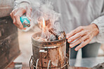 Fire, camping and hands of a senior person start a flame for heating, preparation of food and cooking in nature. Light, heat and woman with a tool for making heat and warmth during an outdoor camp