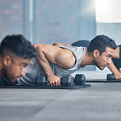 Group, workout and dumbbell push up at gym for muscle, power or