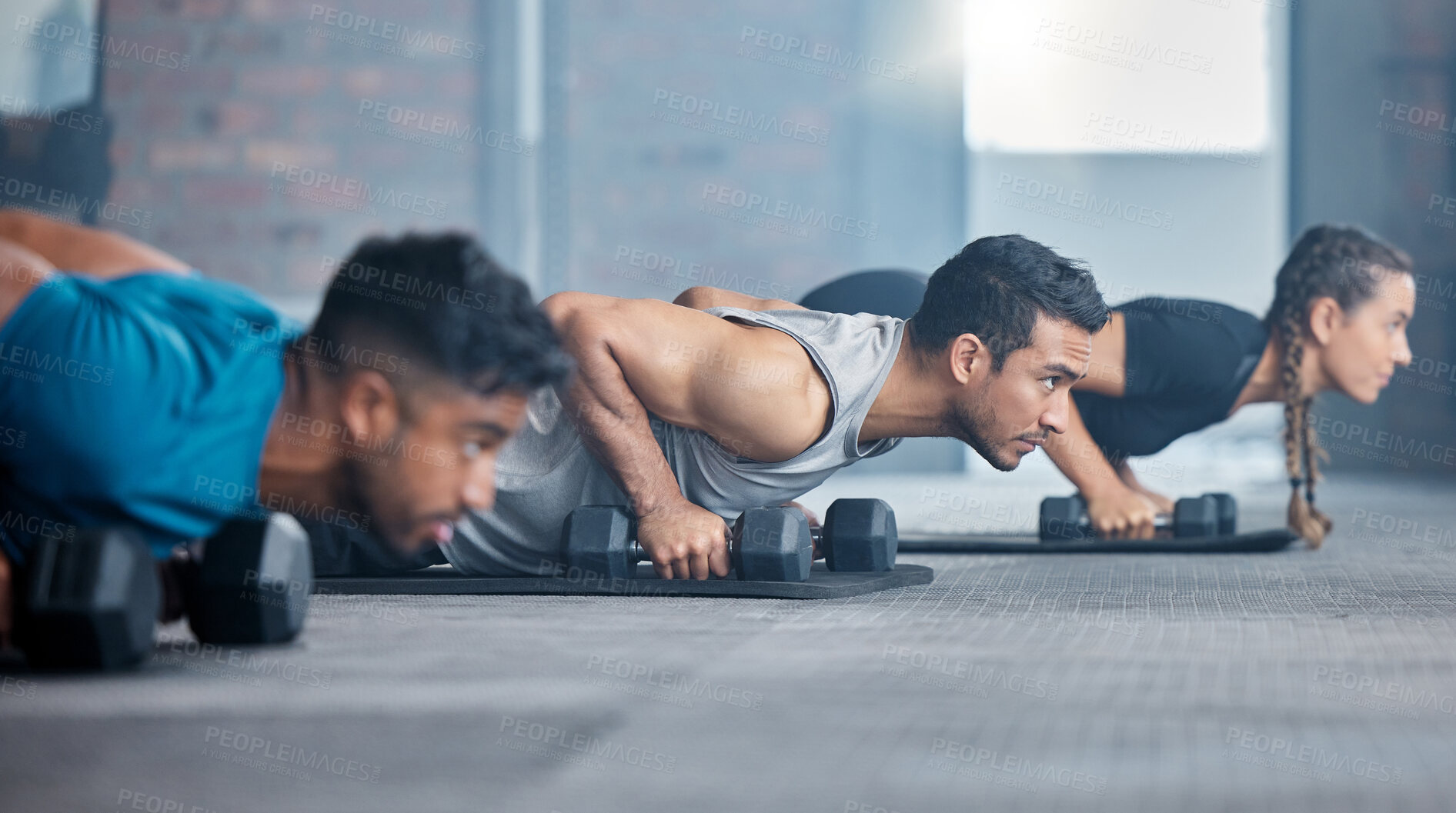 Buy stock photo Fitness, exercise and gym with a personal trainer teaching or training a class workout in a health club. Motivation, coach and dumbbells with a man athlete and student group in a session for strength