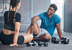 Happy couple, fitness and exercise with personal trainer and client talking about wellness, health and workout plan on gym floor. Happy indian man and woman together for training and motivation