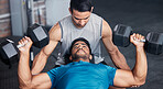 Fitness, personal trainer and workout bench in gym with dumbbell for training, bodybuilding and cardio. Exercise, athlete and professional bodybuilder coach helping client with lifting technique.


