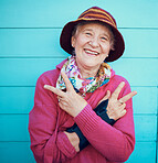 Peace sign, hip hop and portrait of a senior woman in the city with energy, smile and urban fashion. Cool, trendy and elderly grandma with emoji hand in retirement on a blue background or wall