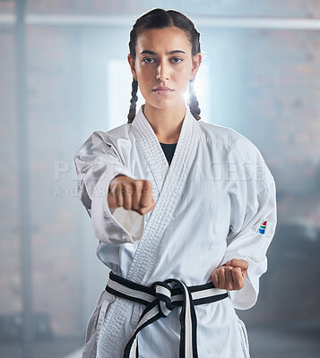 Woman, karate and punching pose in taekwondo fitness, workout or training for black belt competition, fight challenge or self defense. Portrait, martial arts and judo sports person in power exercise