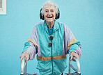 Happy, elderly and woman streaming music, radio or audio with freedom in a cool jacket and headphones. Smile, fashion and excited senior person listening to a song with a blue wall background outdoor