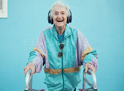 Buy stock photo Portrait, hip hop and old woman streaming music, radio or audio with freedom in a cool jacket and headphones. Smile, fashion and happy senior person listening to a song with a blue wall background
