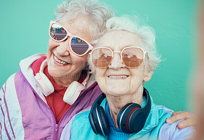 Buy stock photo Senior women, fashion and retro selfie friends with sunglasses, headphones and vintage clothes in retirement. Portrait of cool old people together for pop art and hug profile picture against wall