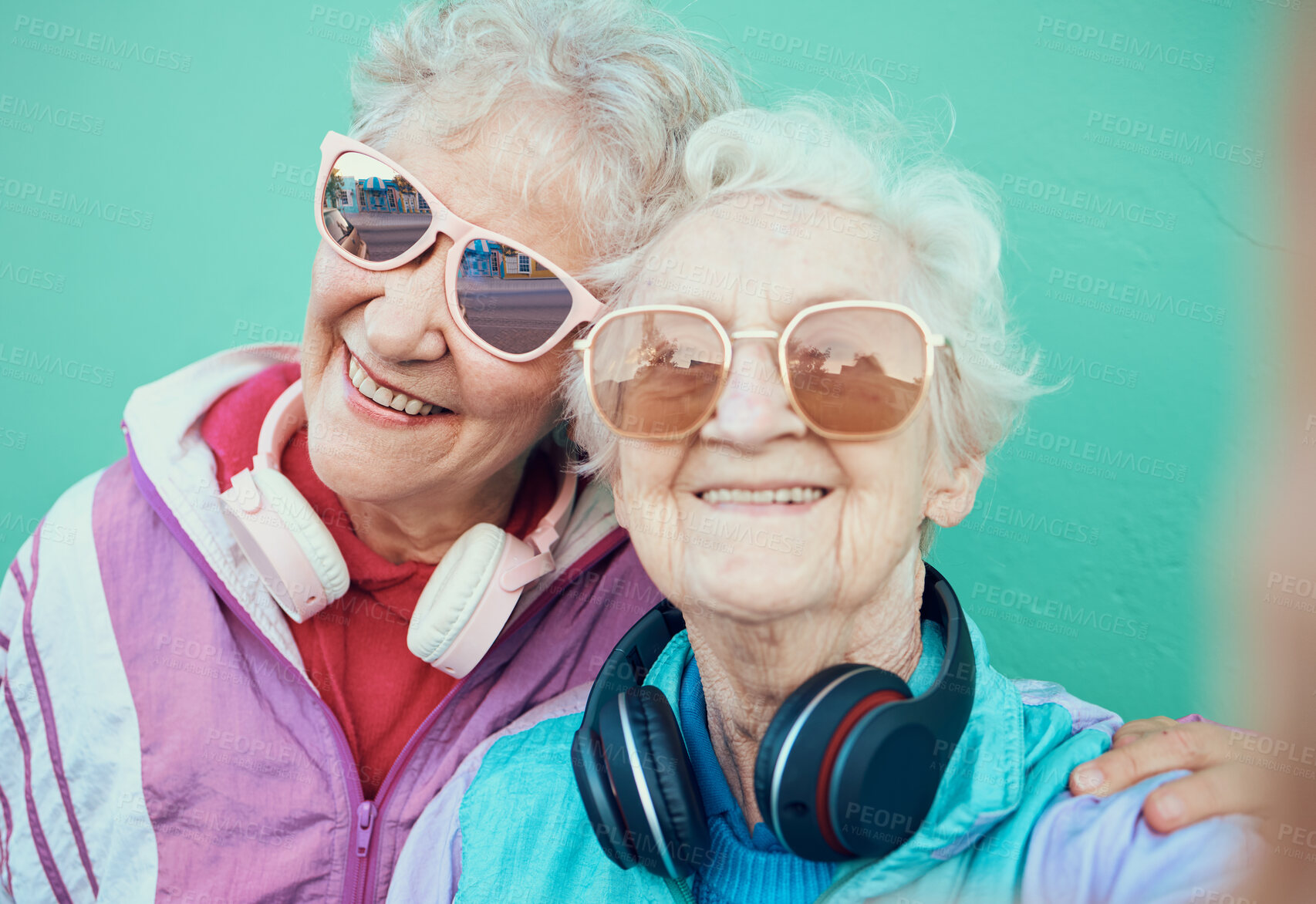 Buy stock photo Senior women, fashion and retro selfie friends with sunglasses, headphones and vintage clothes in retirement. Portrait of cool old people together for pop art and hug profile picture against wall