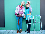 Phone, selfie and disability with senior friends posing for a photograph outdoor on a green wall background. Happy, mobile and walker with a mature woman and friend taking a picture together