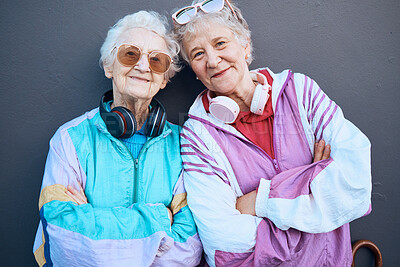 Buy stock photo Portrait, fashion and friends with a senior woman pair standing arms crossed outdoor on a gray wall background. Retirement, happy and bonding with a mature female and friend posing for funky style