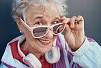 Face portrait and senior woman with sunglasses, headphones and vintage clothing. Fashion, beauty and happy, retired and elderly female in retro, cool and pink designer glasses and outfit with smile.