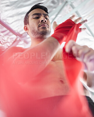 Buy stock photo Fitness, mma and preparation with hand wrap for boxer training, competition or workout with low angle. Boxing, martial arts and athlete man getting ready with fist bandage for wellness exercise.

