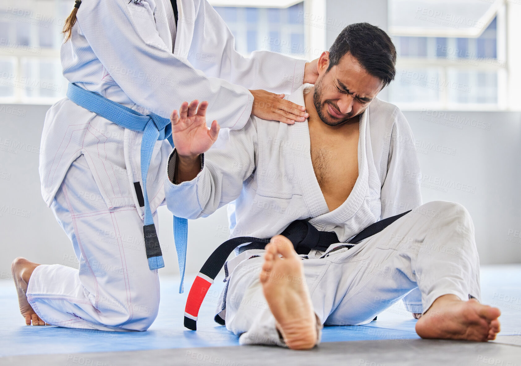 Buy stock photo Karate, sports and neck injury pain of fighter on floor with surrender hand at professional athlete club. Accident, help and tournament of martial arts person in agony with muscle pain.