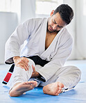 Injury, karate and man with knee pain after an accident in  martial arts training in a wellness studio or dojo. Fitness, taekwondo and fighter with leg pain, emergency or joint pain after a workout