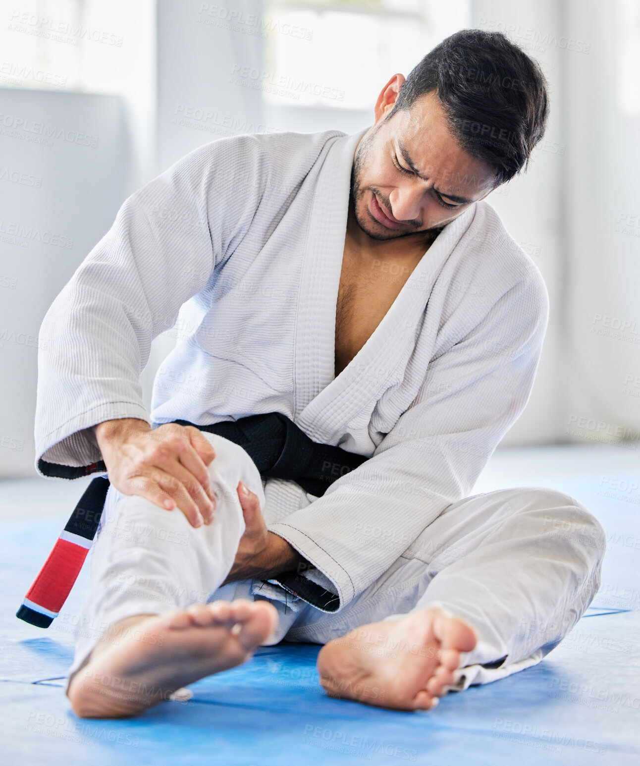Buy stock photo Injury, karate and man with knee pain after an accident in  martial arts training in a wellness studio or dojo. Fitness, taekwondo and fighter with leg pain, emergency or joint pain after a workout