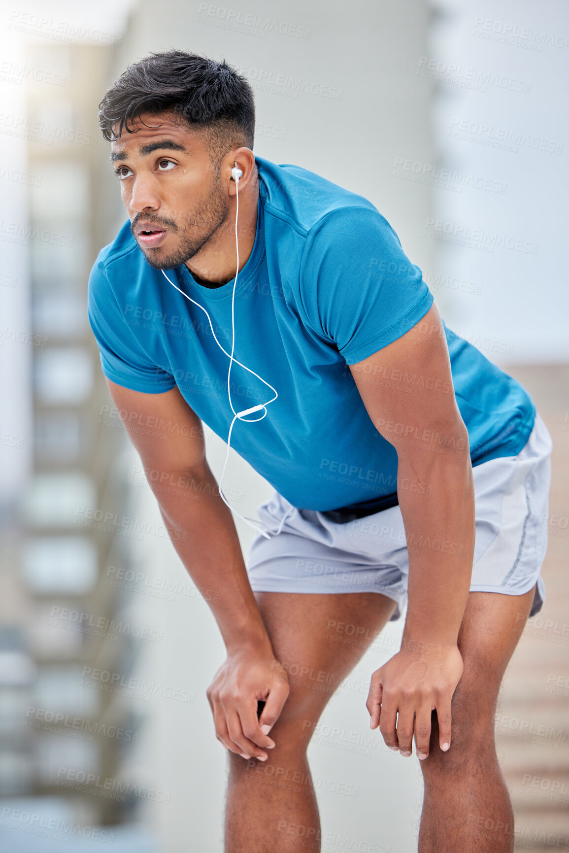 Buy stock photo Tired, fitness and sweat with earphones music for cardio, workout and athletic training break. Exercise, exhausted and sweaty indian man listening to audio streaming on outdoor athlete rest.


