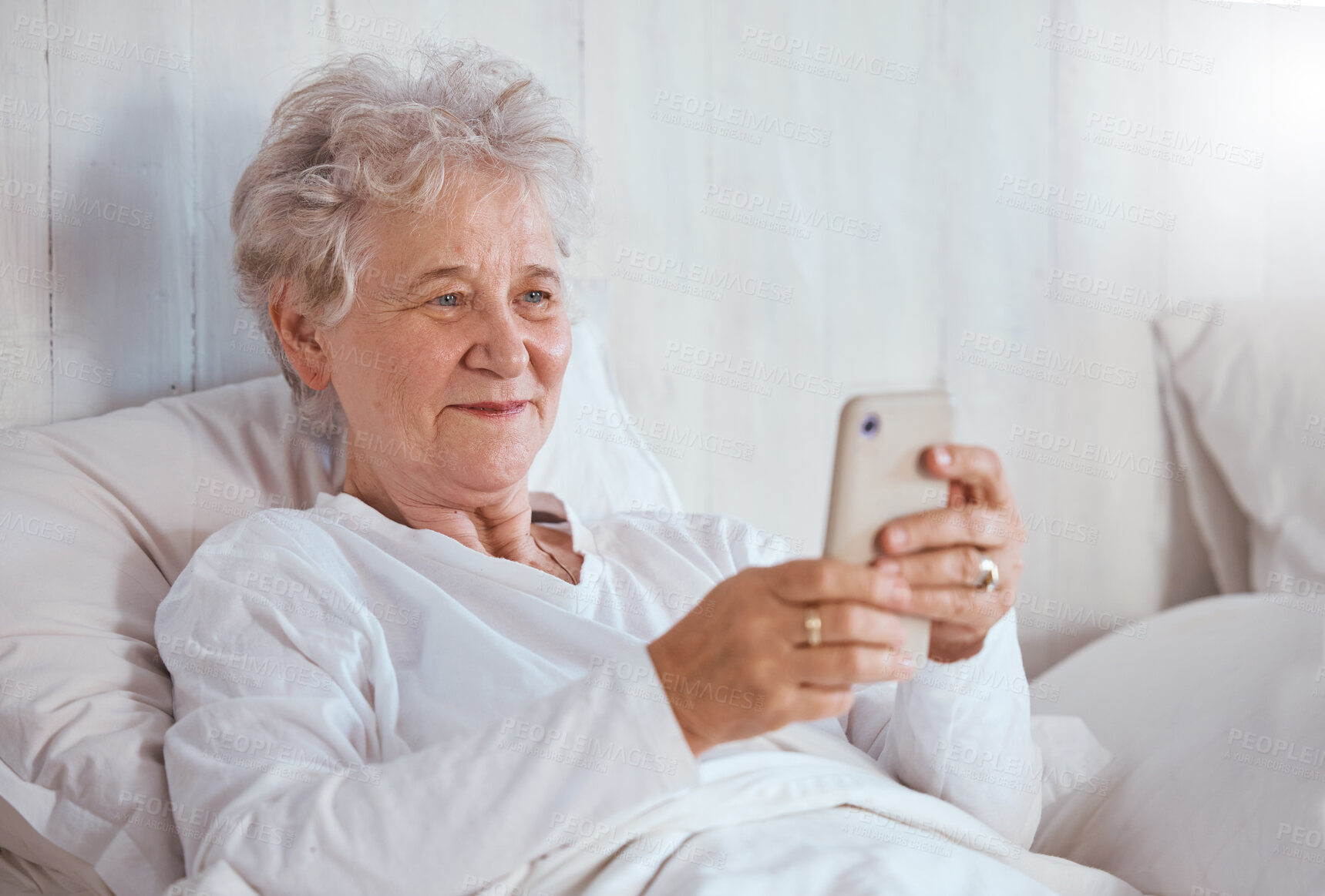 Buy stock photo Bed, phone and relax senior patient search internet, web or online for subscription movie, show or entertainment. Healthcare, elderly care and old woman streaming video in retirement nursing home