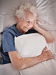 Relax, bedroom and old woman sleeping in peace resting in a house bedroom and dreaming with a pillow in hand. Smile, grandmother or tired elderly person in retirement enjoys comfortable bedding alone