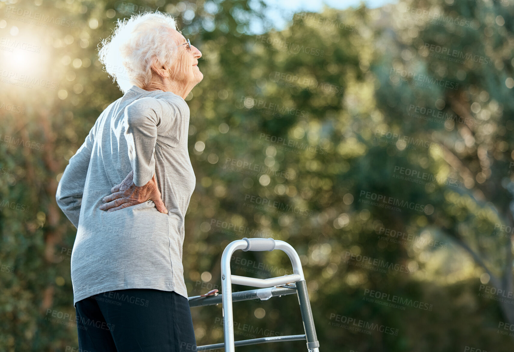 Buy stock photo Senior woman, back pain and walking frame for rehabilitation at park for exercise for arthritis, fibromyalgia or osteoporosis problem. Old woman in nature for air, hope and freedom in retirement