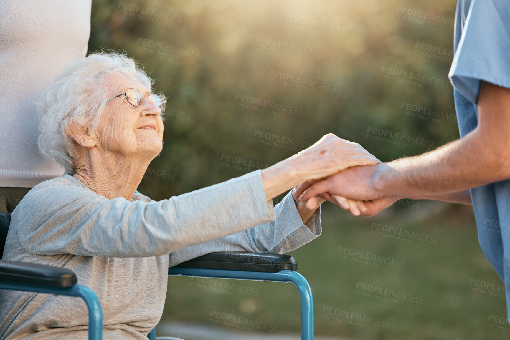 Buy stock photo Elderly woman, wheelchair and caregiver holding hands for support, care and solidarity in nature park. Senior person, patient disability and healthcare nurse communication in retirement home outdoor