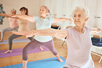 Exercise, yoga and group of senior women in gym training for fitness, healthcare and wellness. Pilates, meditation and retired females stretching arms in fitness center for balance workout together.
