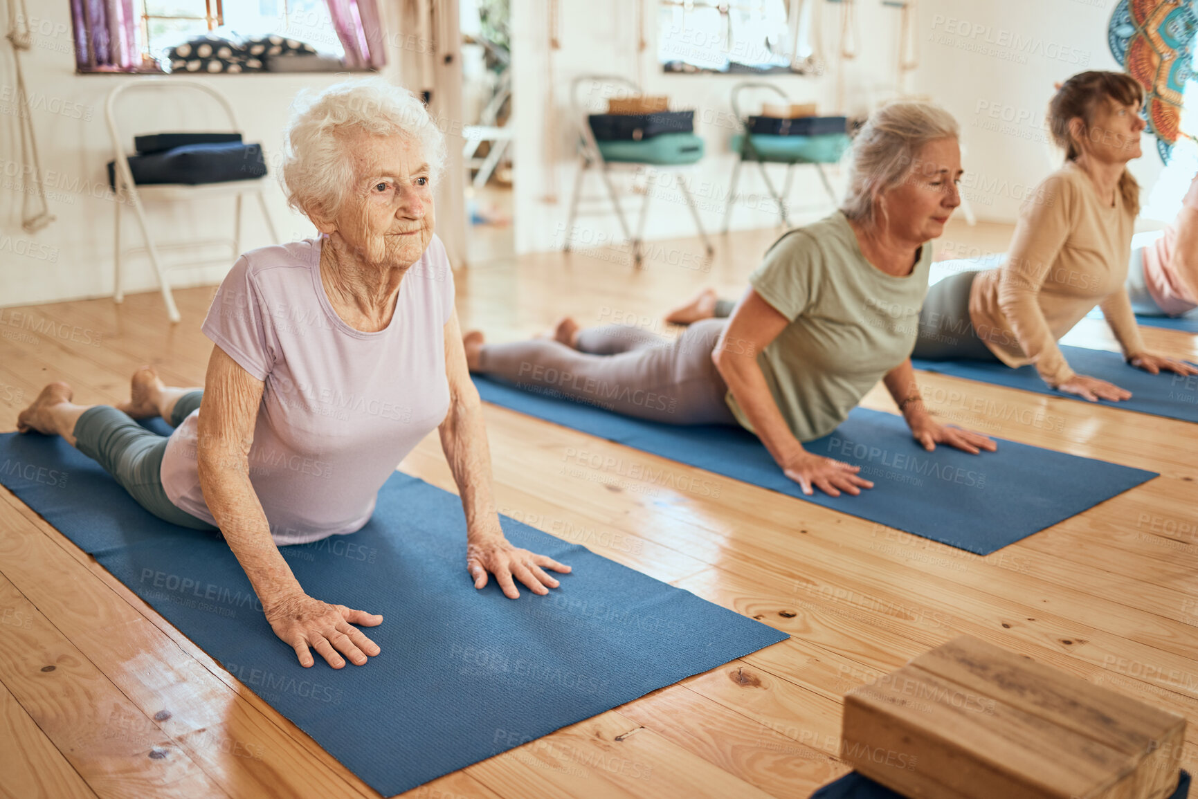 Buy stock photo Yoga, stretching and senior women at a wellness, rehabilitation and retirement spa community for exercise, fitness and health. Workout, pilates and healthy elderly people, friends or group on floor