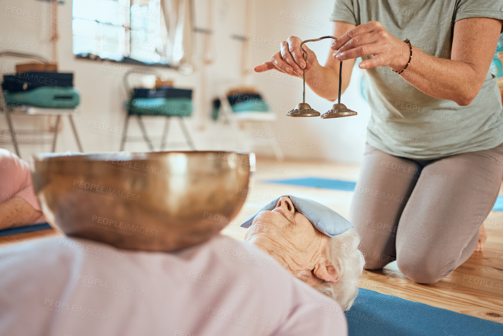 Buy stock photo Sound bell, healing and senior woman giving alternative medicine support, music therapy or audio holistic healthcare. Tibetan singing bowl, chakra wellness and aura sound bath meditation for zen lady