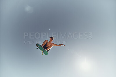 Skateboard, man and sky background, air and action, extreme sports and summer training, outdoor skills and hobby. Below of skater athlete, freedom and flying jump, energy and risk of youth culture