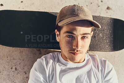 Buy stock photo Skateboard, portrait and young man chilling at a skate park alone in the city while on a break. Sports, relax and guy resting while skateboarding training for a competition at a park in a urban town.